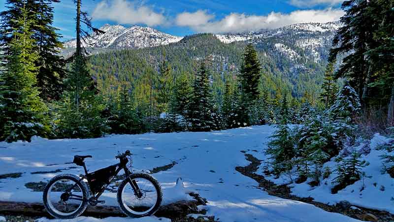 photo of a mountain bike parked on a trail in winter